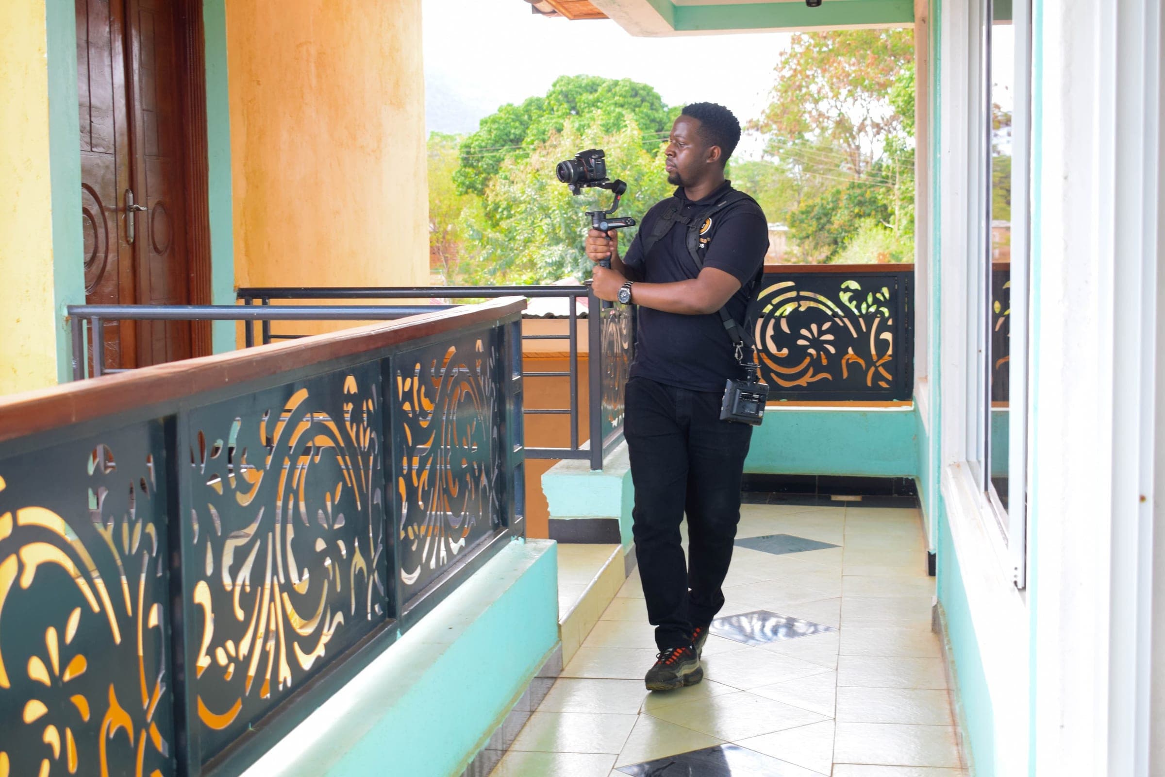 Videographer walking a colourful balcony with a camera on a gimbal