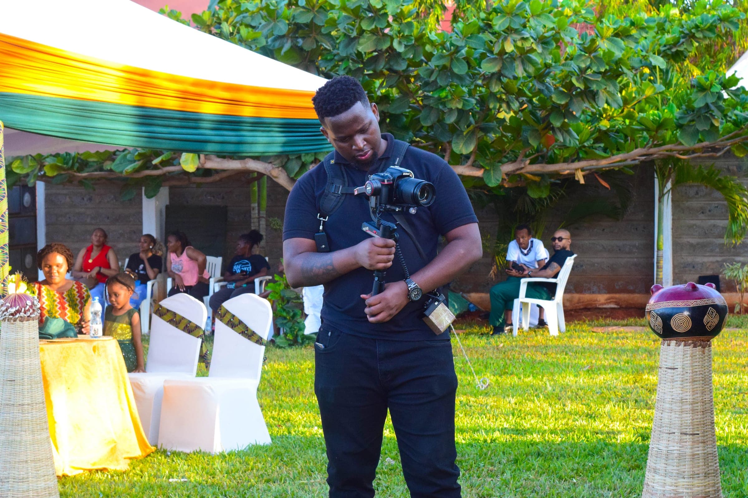 Videographer with a camera gimbal filming a garden reception