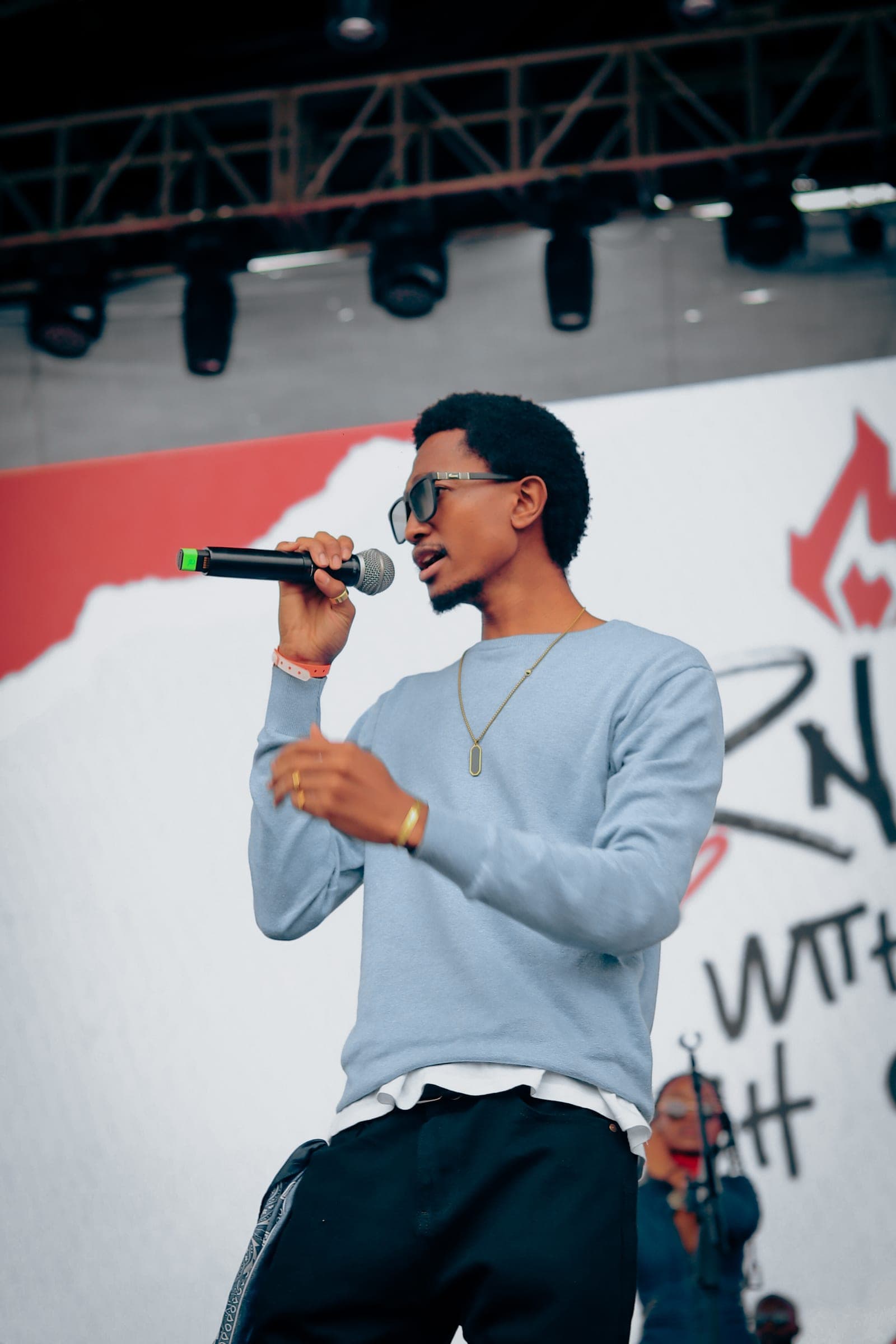 Performer singing into a microphone on a festival stage