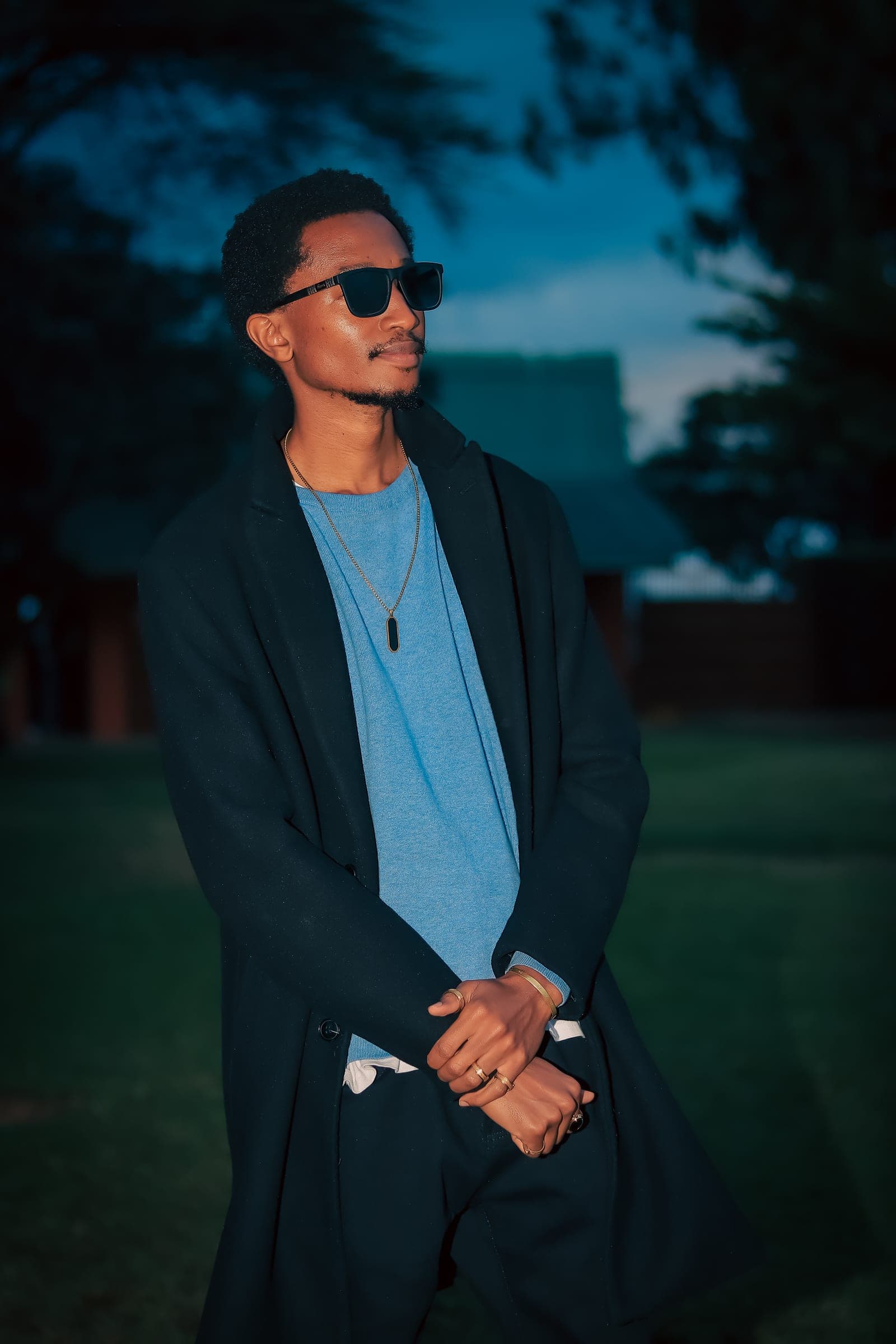 Dusk portrait of a man in sunglasses and a long black coat