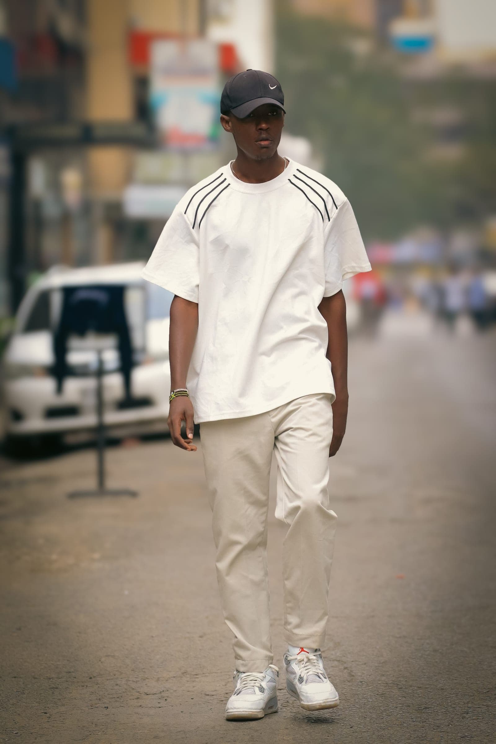 Man in an all-white outfit walking down a Nairobi street